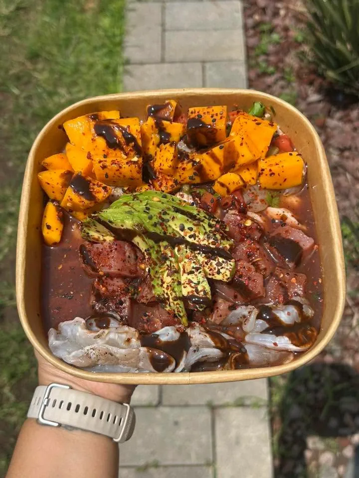 Mariscos bañados en salsa negra con mango y aguacate